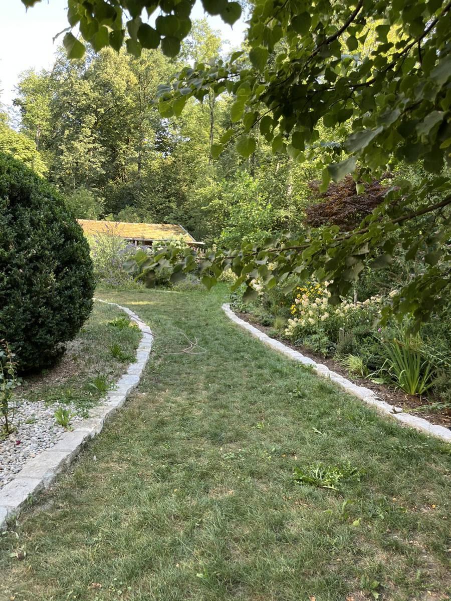 Rasenweg zwischen zwei Beeten, beidseitig mit Granitpflaster eingefasst